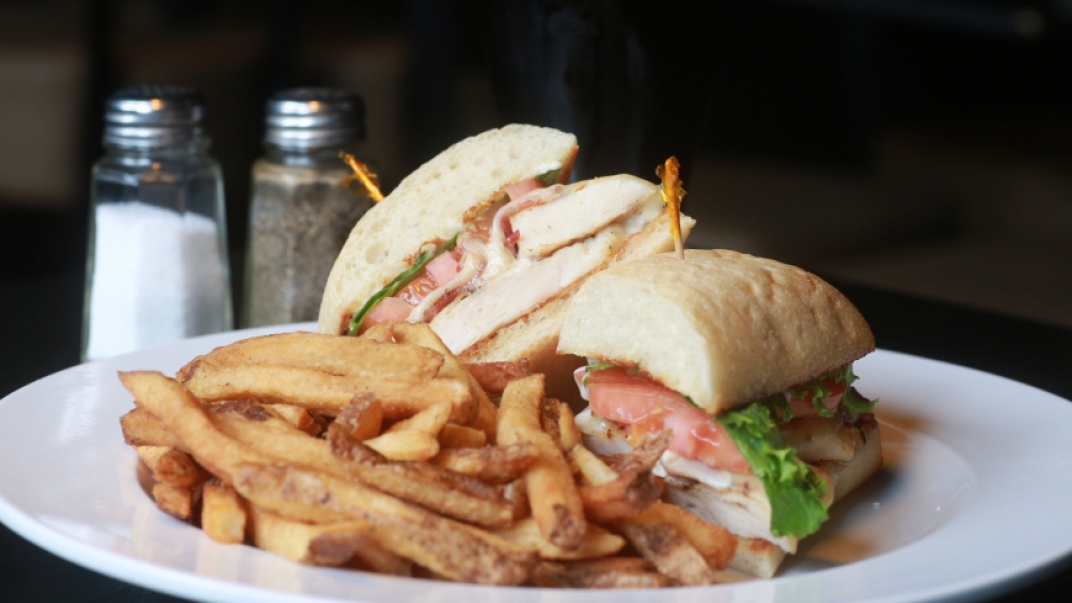 a white plate with a deli sandwich and fries