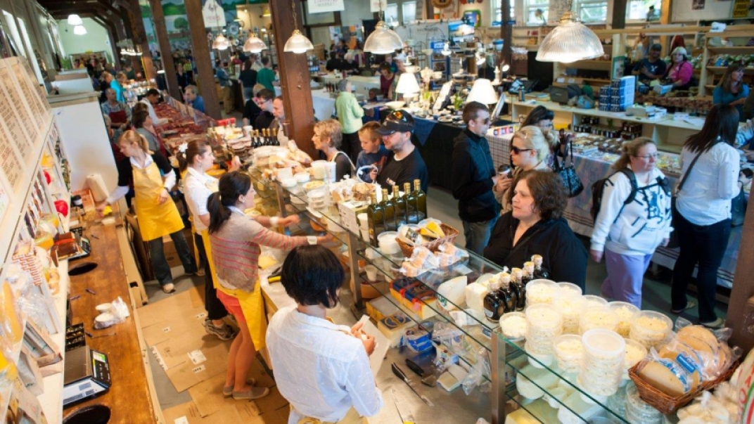 People working at a food market and others ordering food