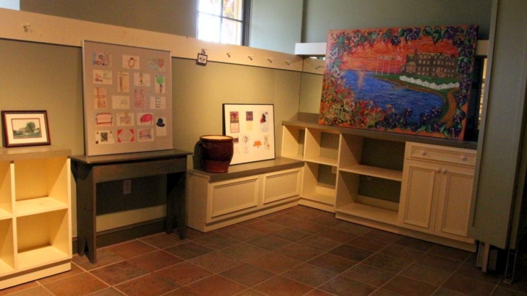 gallery display of art on top of cabinets and shelves