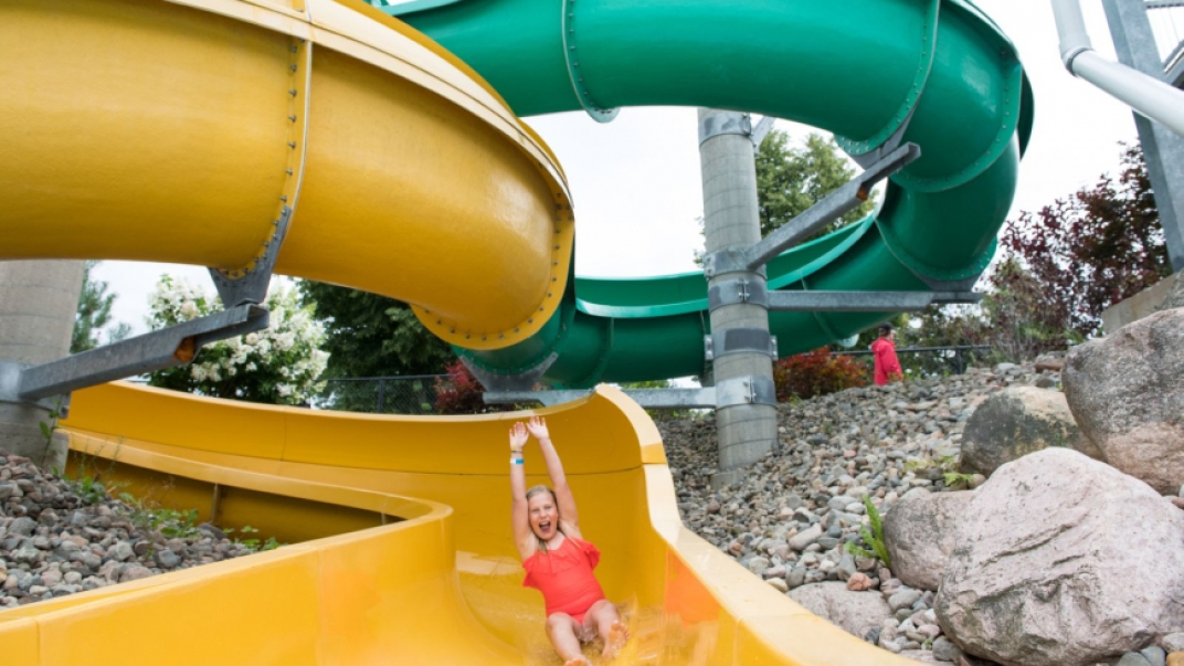 Girl going down yellow water slide