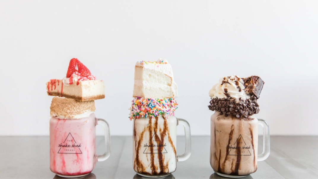 strawberry, vanilla and chocolate shakes with cake on top