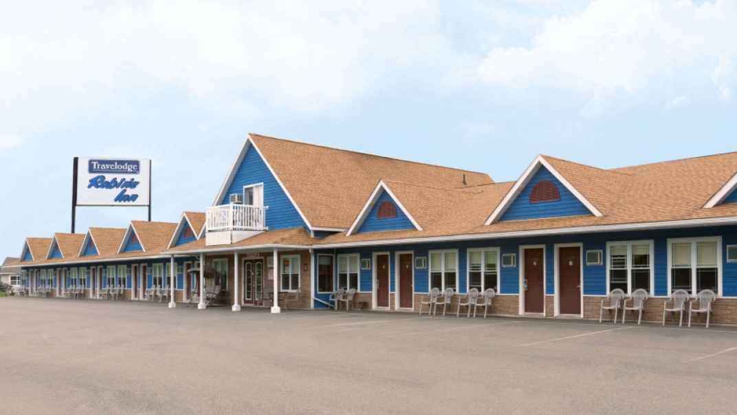 Travelodge motel with brown roof and blue siding