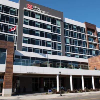 Image of the outside of the Hilton. A brown and white building.