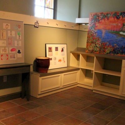 gallery display of art on top of cabinets and shelves