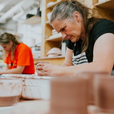 Two women in a workshop working with clay