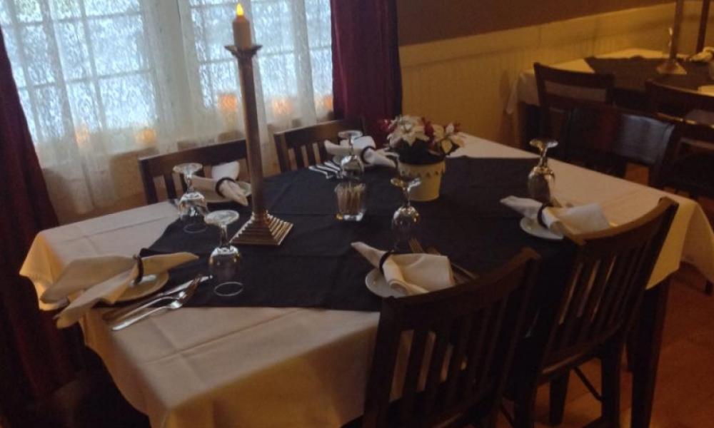a formally dressed table with candles and placemats 