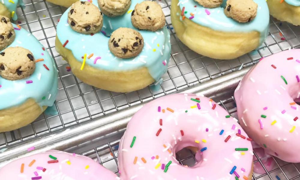 donuts with pink icing and sprinkles and blue icing topped with cookies