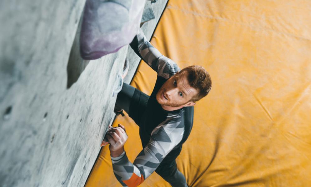 A man doing indoor rock climbing 