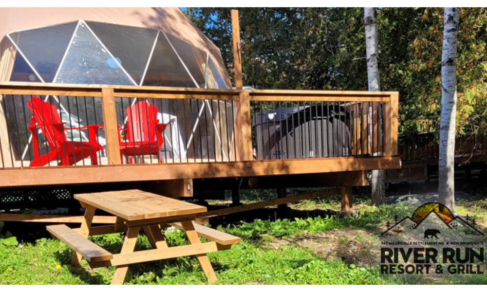 glamping tent with a deck and two bright red chairs