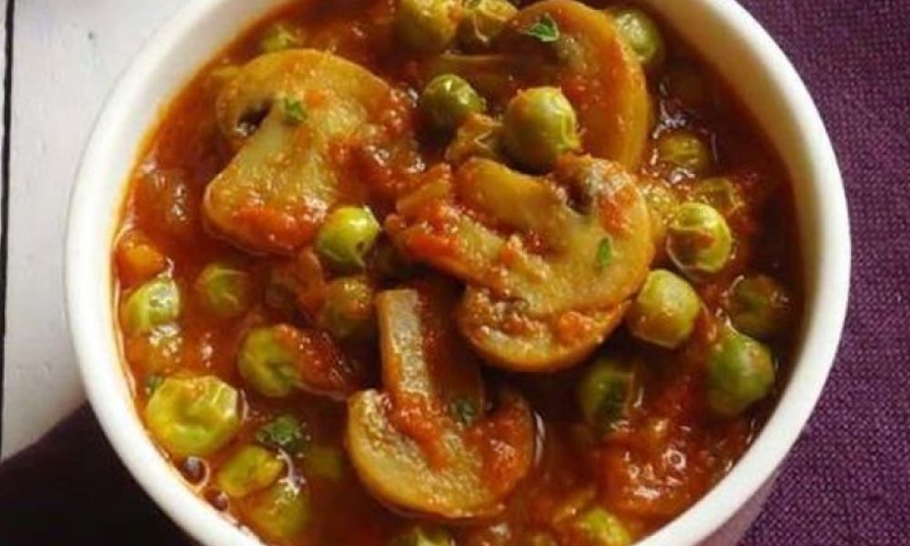 a curry dish with peas and mushrooms in a tomato base