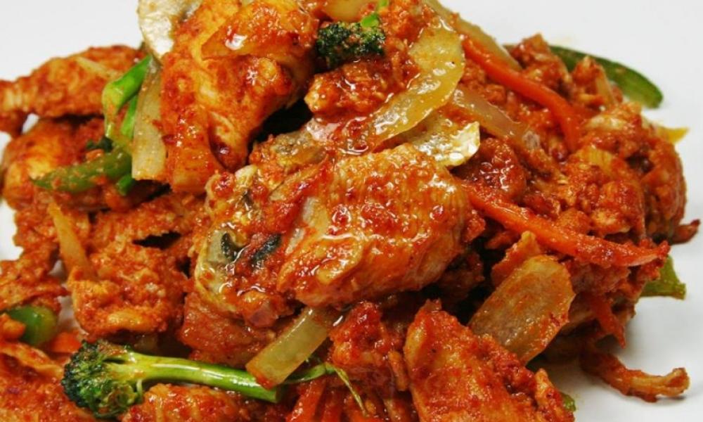 a tomato based curry dish with broccoli and onions