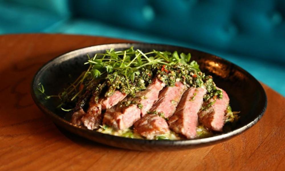 steak with garnish on a black plate