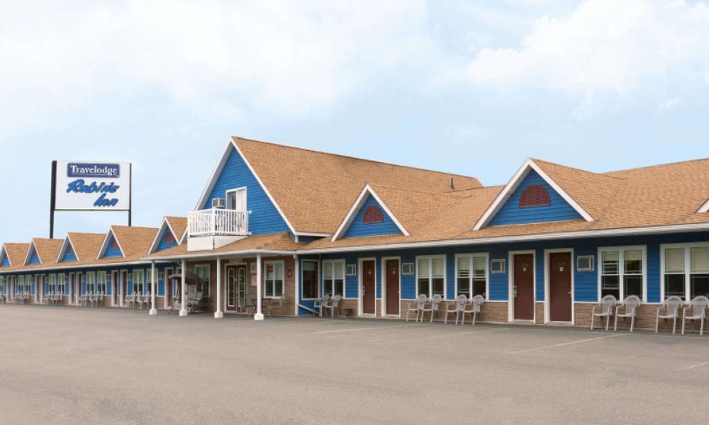 Travelodge motel with brown roof and blue siding