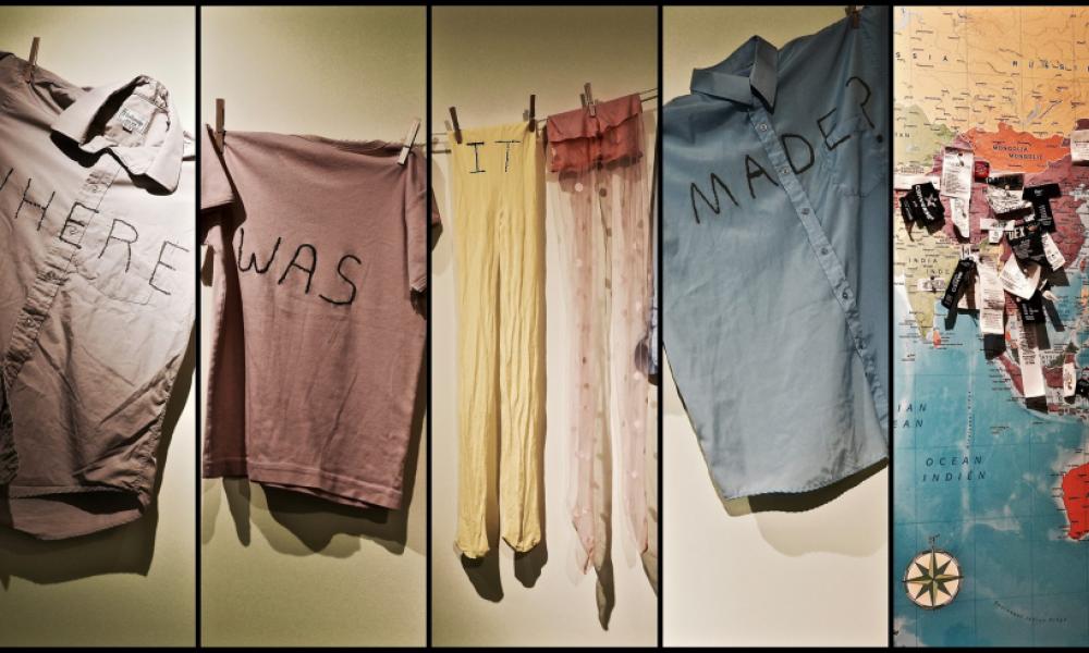 clothing hanging on a clothes line with the words "where was it made" written across them and a map with pins showing where clothes are made