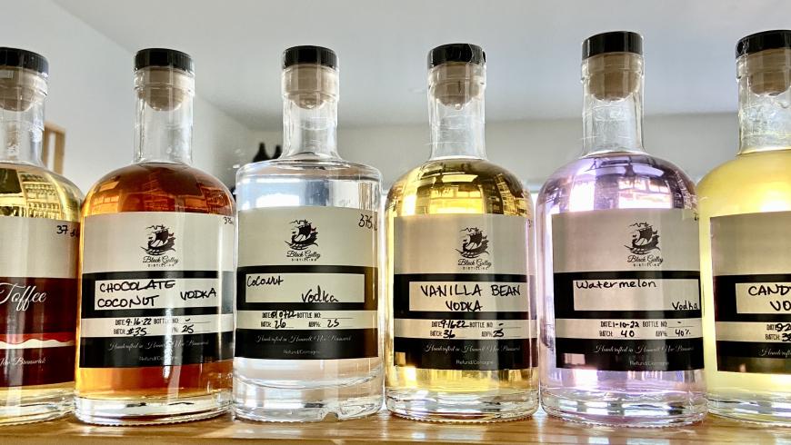 bottles of alcohol lined up in a row on a wooden surface